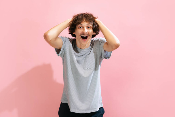 Portrait of young man with mustache posing, showing emotions of happy excitement isolated over pink background. Concept of youth, fashion, lifestyle, emotions, facial expression. Copy space for ad - Foto, Bild