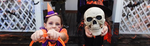 Девушка скрывает лицо с жутким черепом рядом друг в костюме клоуна, баннер - Фото, изображение