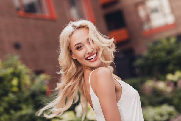 Photo of excited dreamy young wavy woman wear white top enjoying sunshine dancing outside city park. - Fotoğraf, Görsel