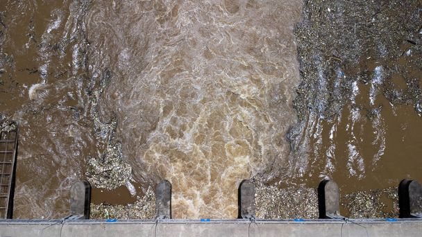 Vista aérea da água liberada do canal de drenagem da barragem de concreto como o transbordamento na estação chuvosa. Vista superior dos fluxos de água da floresta marrom turva de uma barragem no norte rural da Tailândia. - Foto, Imagem