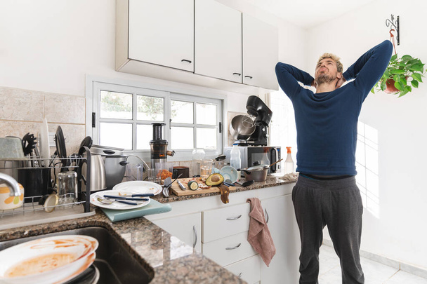 Caucasian man complaining in the morning about dirty kitchen and full of rubbish - 写真・画像