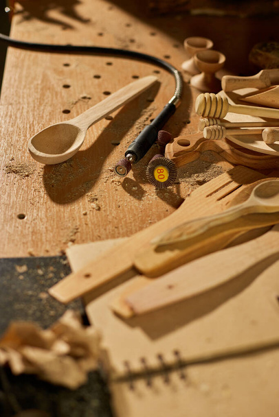 Lugar de trabajo con herramientas de trabajo de energía más grave para utensilios de madera cuchara, tallado, máquina amoladora en el taller. Creación de negocios artesanales de souvenirs - Foto, imagen