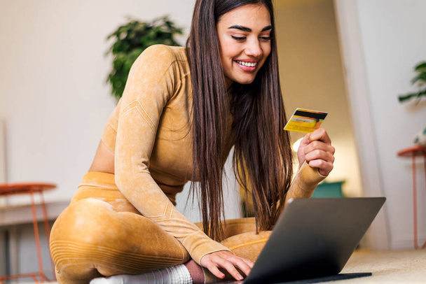 Feliz joven, mujer segura, asegurándose de que su cuenta bancaria está actualizada, en casa, utilizando el ordenador portátil. - Foto, imagen