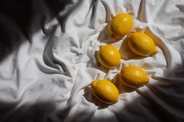 fresh yellow lemons in sunlight  on bed on bed. hard light - Photo, Image