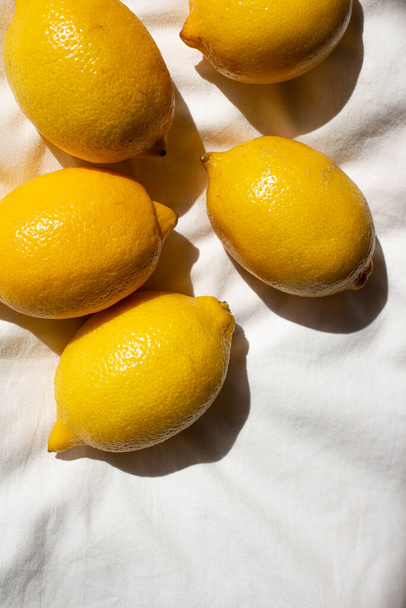 friss sárga citrom a napfényben az ágyon. kemény fény - Fotó, kép
