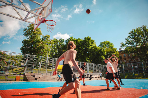 Lviv, Ukrayna - 28 Mayıs 2022: Erkekler açık havada güneşli bir yaz günü basketbol oynuyorlar - Fotoğraf, Görsel