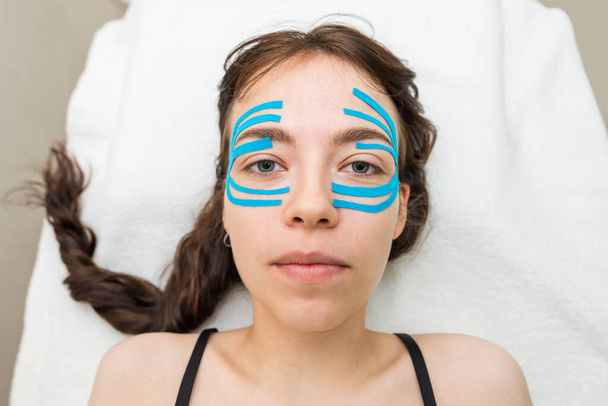 Obličejová páska, detailní záběr dívčí tváře s antireflexní kosmetickou páskou. Estetické nahrávání obličeje. Neinvazivní metoda proti stárnutí ke snížení vrásek - Fotografie, Obrázek