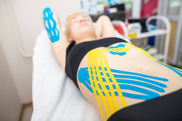 kinesio tape on the abdomen of a young woman - Foto, Imagem