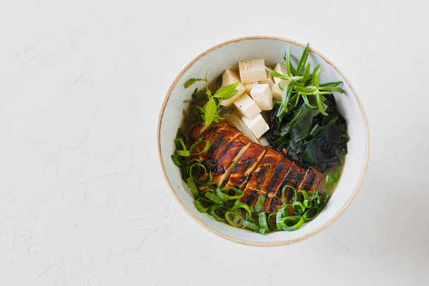 Soup miso shiru. Tofu, noodles, wakame, white background,chicken - Fotó, kép