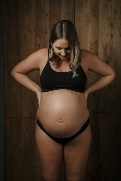 Portrait of expectant mother lovely looking down at her belly. High quality photo - Foto, imagen