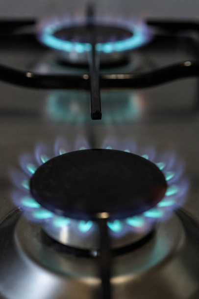 Close-up of a flame of methane gas stove in a domestic kitchen related with gas price energy crisis in europe for an expensive costs. - Photo, Image
