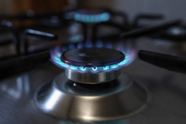 Close-up de uma chama de fogão a gás metano em uma cozinha doméstica relacionada com a crise energética do preço do gás na Europa por um custo caro. - Foto, Imagem