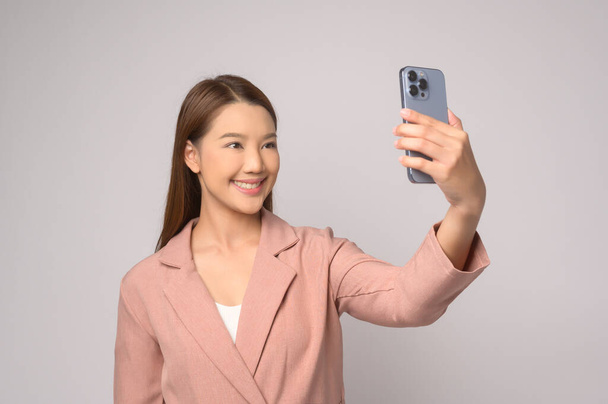 A Young asian woman using smartphone over white background, technology concept. 		 - Фото, изображение