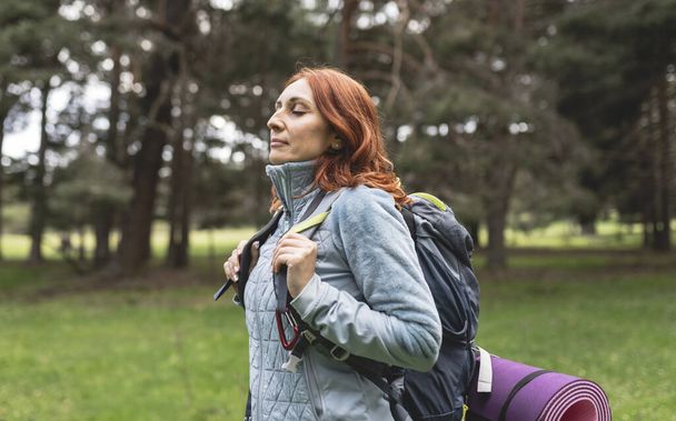 mature woman, traveler backpacking nature camping, happy with closed eyes breathing fresh air. - Фото, изображение