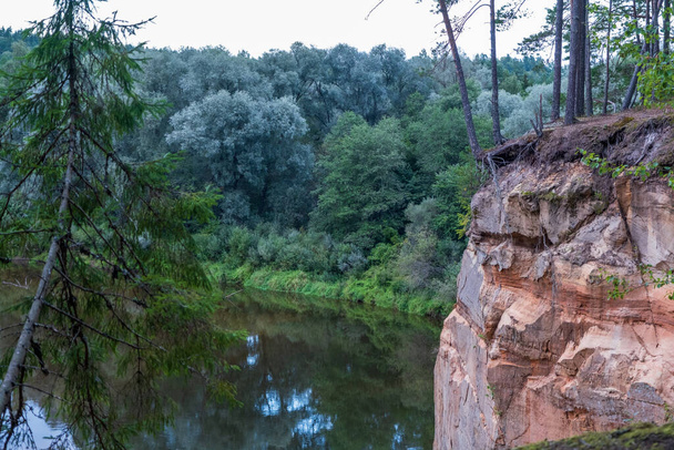 Malowniczy krajobraz rzeki Gauja. Piaszczyste kamienie na brzegu. Letnia przyroda na Łotwie. Park Narodowy Gaujas. - Zdjęcie, obraz
