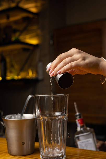 Een barman bereidt een cocktail in de bar van het restaurant - Foto, afbeelding