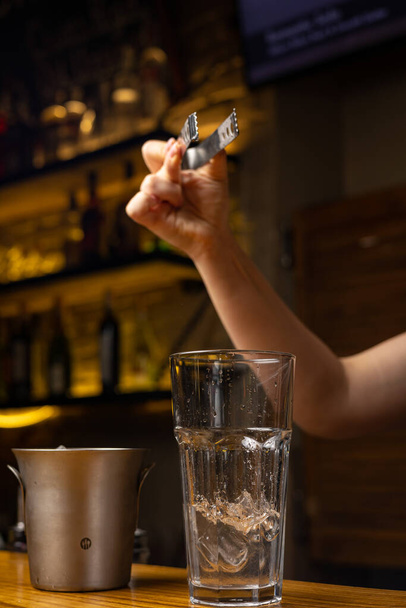 A bartender prepares a cocktail at the restaurant bar - Foto, afbeelding