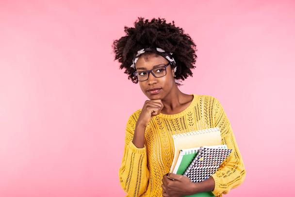 美しい若いアフリカ系アメリカ人女性がノートを持ち、眼鏡をかけている。顔を考えてる。学生生活 - 写真・画像