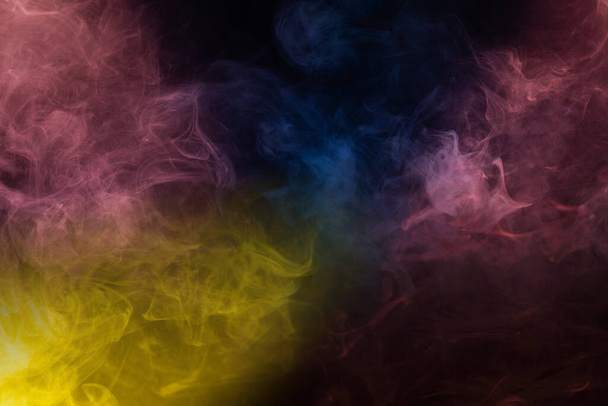 Yellow and pink steam on a black background. Copy space. - Фото, зображення