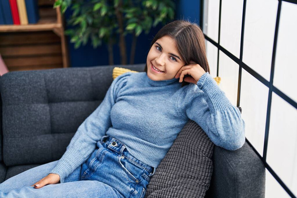Young beautiful hispanic woman smiling confident lying on sofa at home - Fotografie, Obrázek
