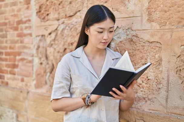 Mujer china leyendo libro en la calle - Foto, Imagen