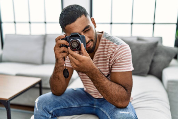 młody arabski człowiek uśmiechnięty pewnie za pomocą kamery w domu - Zdjęcie, obraz