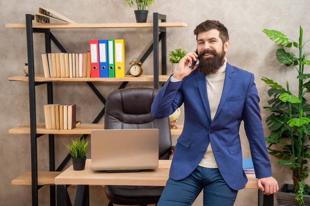 Happy lawyer in suit talking on mobile phone sitting at office desk, cellular. - Fotoğraf, Görsel