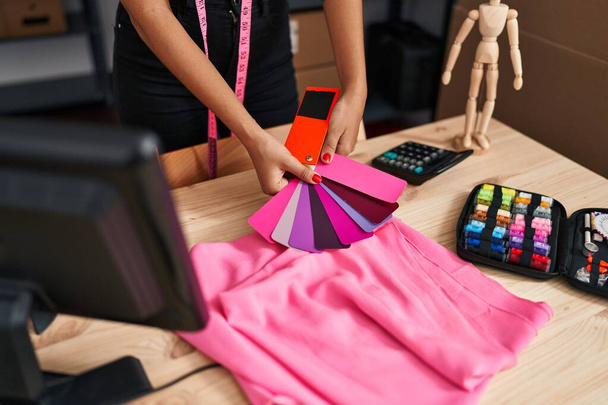 Молодая латиноамериканка из электронной коммерции выбирает цвет ткани в дизайнерской студии - Фото, изображение