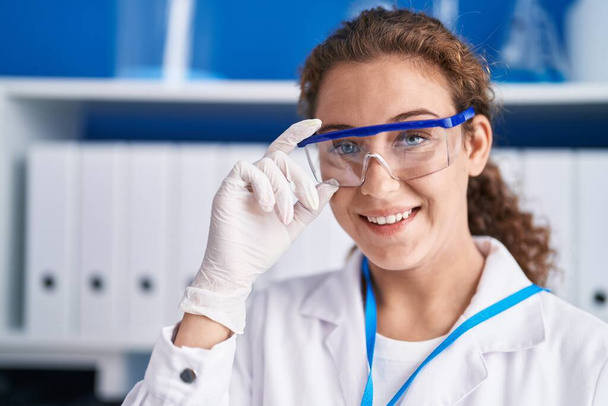 Молода красива іспаномовна жінка вчений посміхається впевнено стоїть в лабораторії
 - Фото, зображення