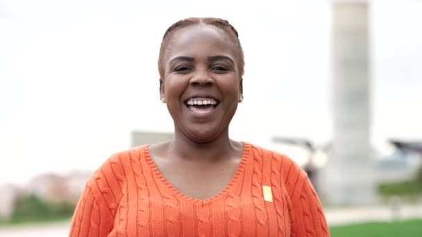 Portrét zakřivené africké americké ženy usmívající se na kameru venku - Záběry, video