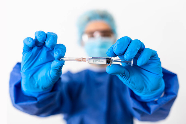 Female doctor holding COVID-19 vaccine. Healthcare And Medical concept.Vaccine vial dose flu shot drug needle syringe,medical concept vaccination hypodermic injection treatment - Photo, image