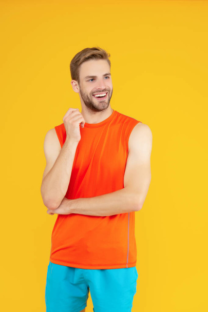 Athletic man looking aside. Happy sportsman isolated on yellow. Sporting man studio. Fitness and sport. Athletic fitness. Sport and recreational activity. - 写真・画像