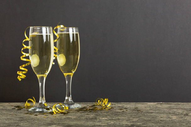 Champagne glasses and christmas decor on colored holiday background. Flat lay New Year decorations. - 写真・画像