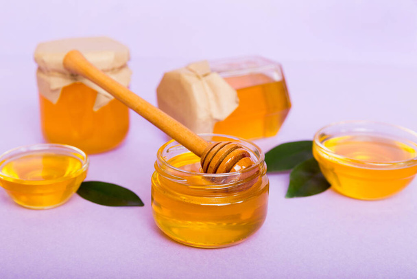 Miel en pot avec feuilles et trempette au miel sur fond coloré vue du dessus avec copie de texte. - Photo, image