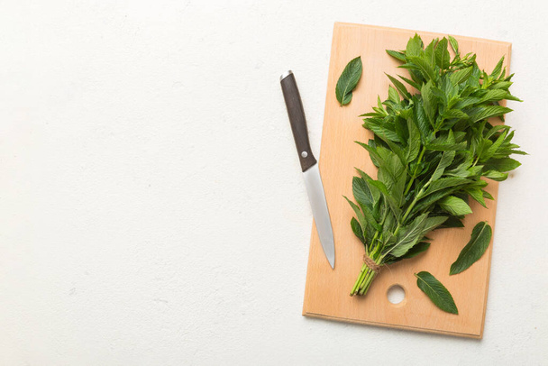 Bunch of fresh mint on the cutting boards, colored background top view. - Photo, Image