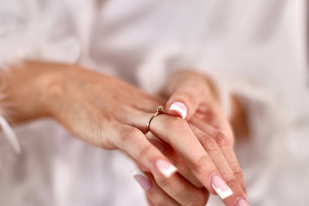 The bride puts a wedding ring on her finger. Preparation for the wedding. - 写真・画像