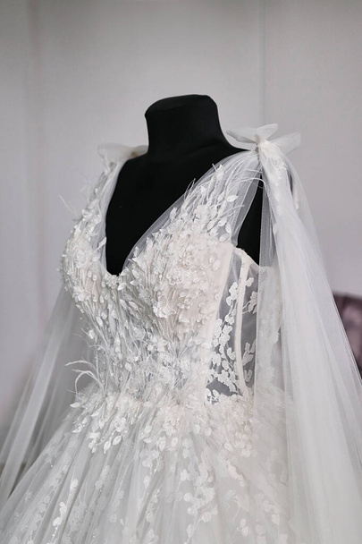 A menyasszony ruhája egy próbababán függ. Felkészülés az esküvőre. - Fotó, kép