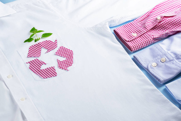 Reciclaje textil. Símbolo de reciclaje de ropa a cuadros en la maqueta de camisa blanca. Industria de la moda ecológica y sostenible. - Foto, imagen