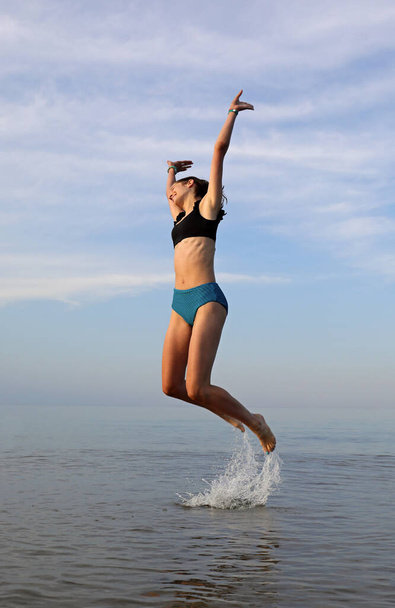 saltar da água de uma jovem esbelta símbolo de felicidade e alegria - Foto, Imagem