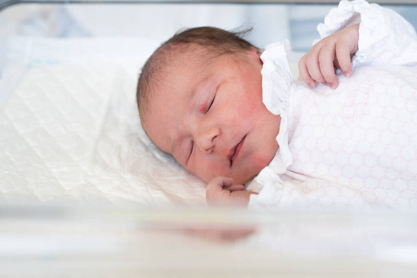 novorozeně. novorozenec zblízka leží se zavřenýma očima v nemocnici porodnice. životní styl šťastný rodina dítě sen koncept. roztomilé novorozeně dítě zabalené v dece - Fotografie, Obrázek