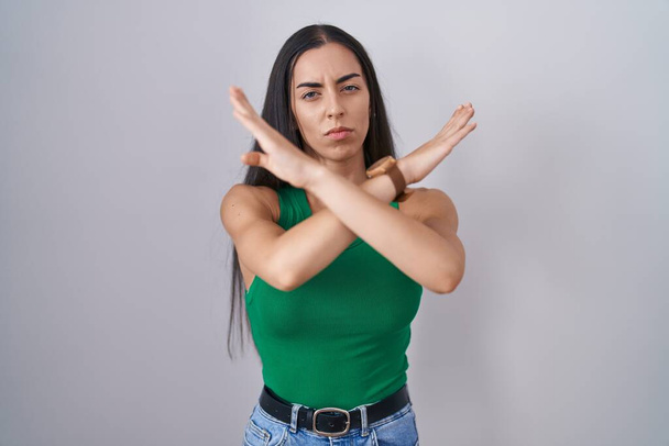Young woman standing over isolated background rejection expression crossing arms doing negative sign, angry face  - Foto, Imagem