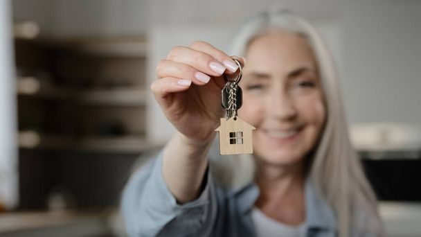 Old happy woman homeowner buyer female mature lady seller realtor tenant adult caucasian granny show bunch keys of accommodation house rental flat win new property apartment buy loan housing dwelling - Foto, Bild