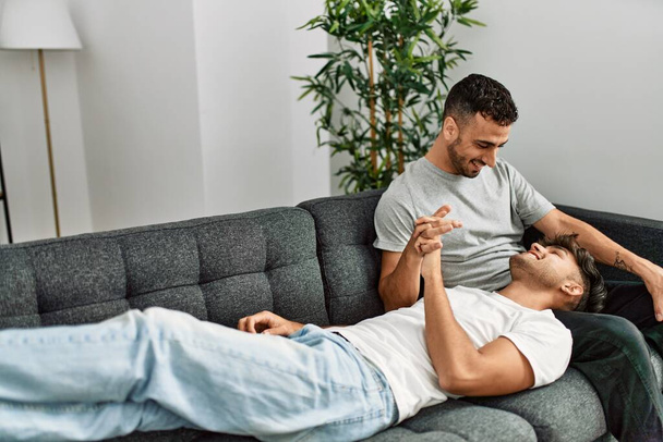 Two hispanic men couple smiling confident sitting on sofa at home - Foto, Imagem