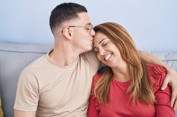 Mies ja nainen äiti ja poika halaavat toisiaan ja suutelevat sohvalla kotona - Valokuva, kuva