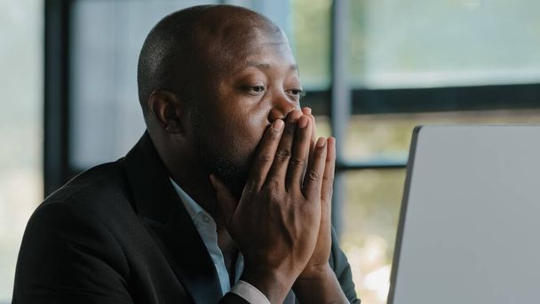 Tired stressful african male adult sad businessman feel tiredness discomfort eyestrain fatigue pain from hard overwhelmed computer work massaging dry irritable eyes exhaustion unwell health concept - 写真・画像