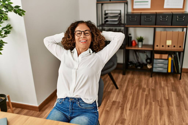 Middle age hispanic woman smiling confident relaxing at office - Photo, Image