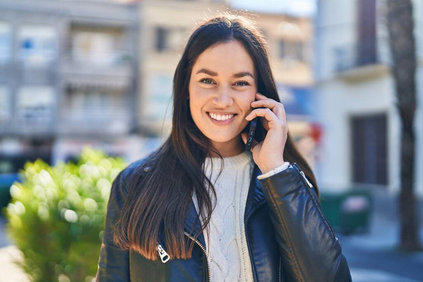 Jeune femme souriant confiant parler sur le smartphone au parc - Photo, image