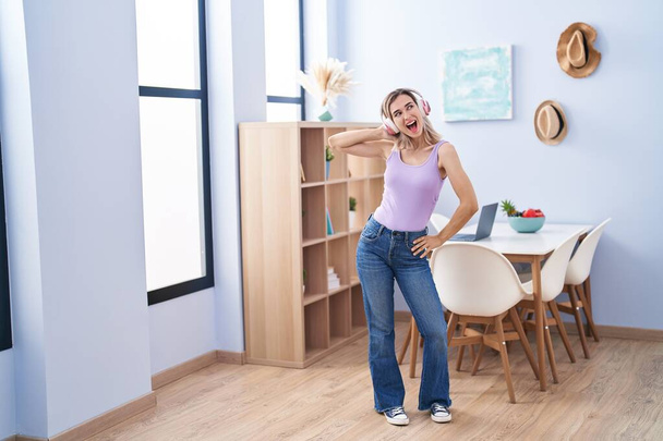 Young woman smiling confident listening to music and dancing at home - Photo, image