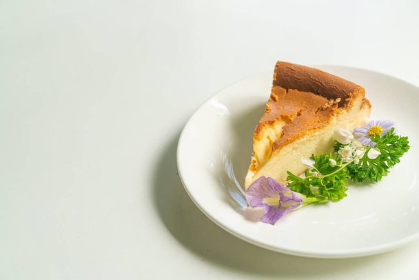 Basque Burnt Cheesecake decoratoin with flowers on white plate - Photo, Image