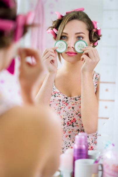 young woman in bathrobe with cucumber on eyes - Photo, image